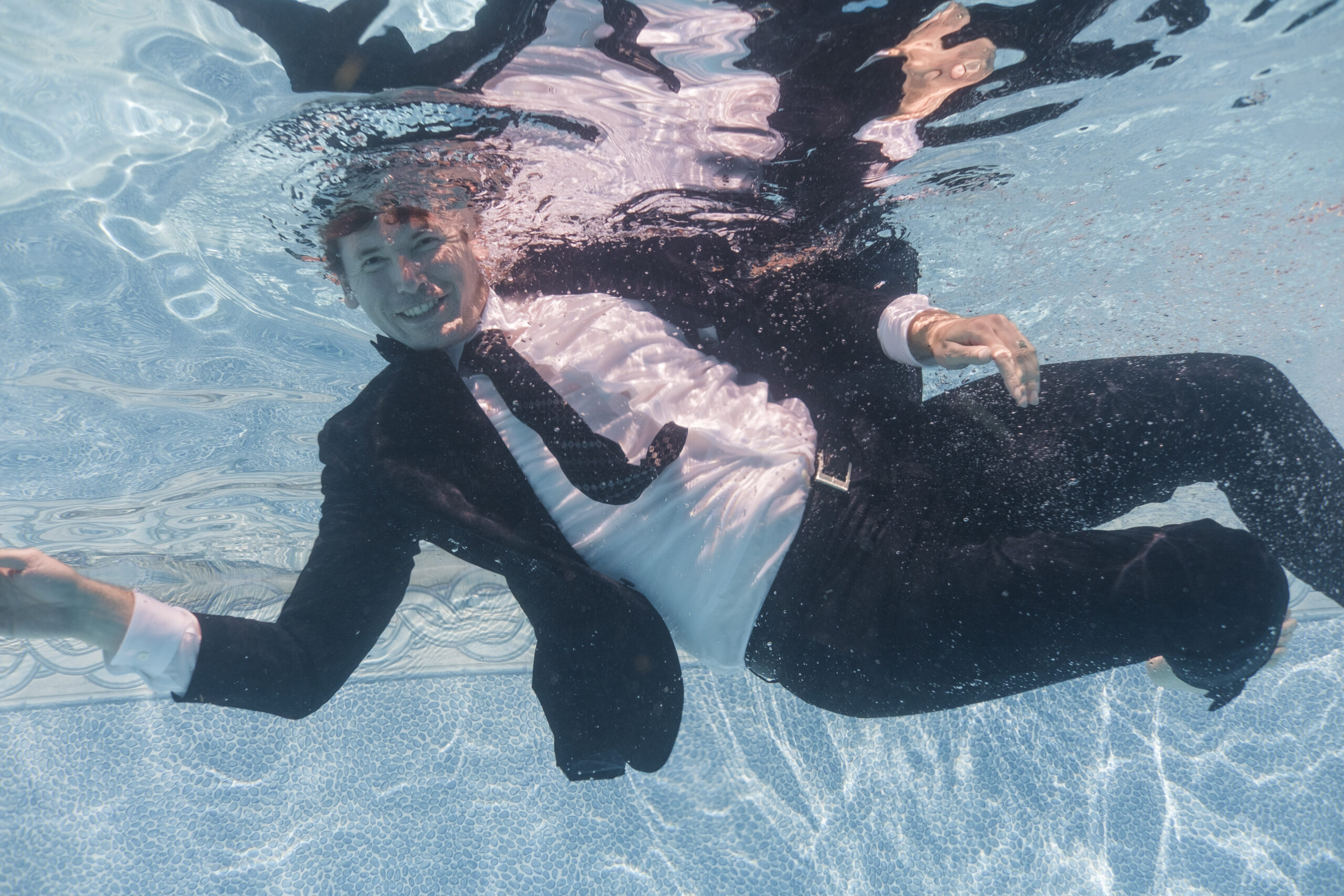 Advertising on Bing by Neil Colvin in a black suit while swimming in blue water.